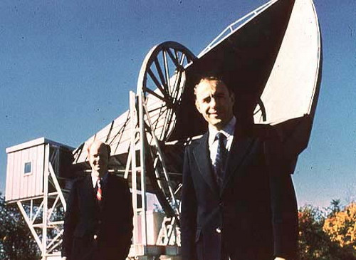 A. Penzias és R. W. Wilson, háttérben a kozmikus háttérsugárzás felfedezését lehetővé tevő antennával